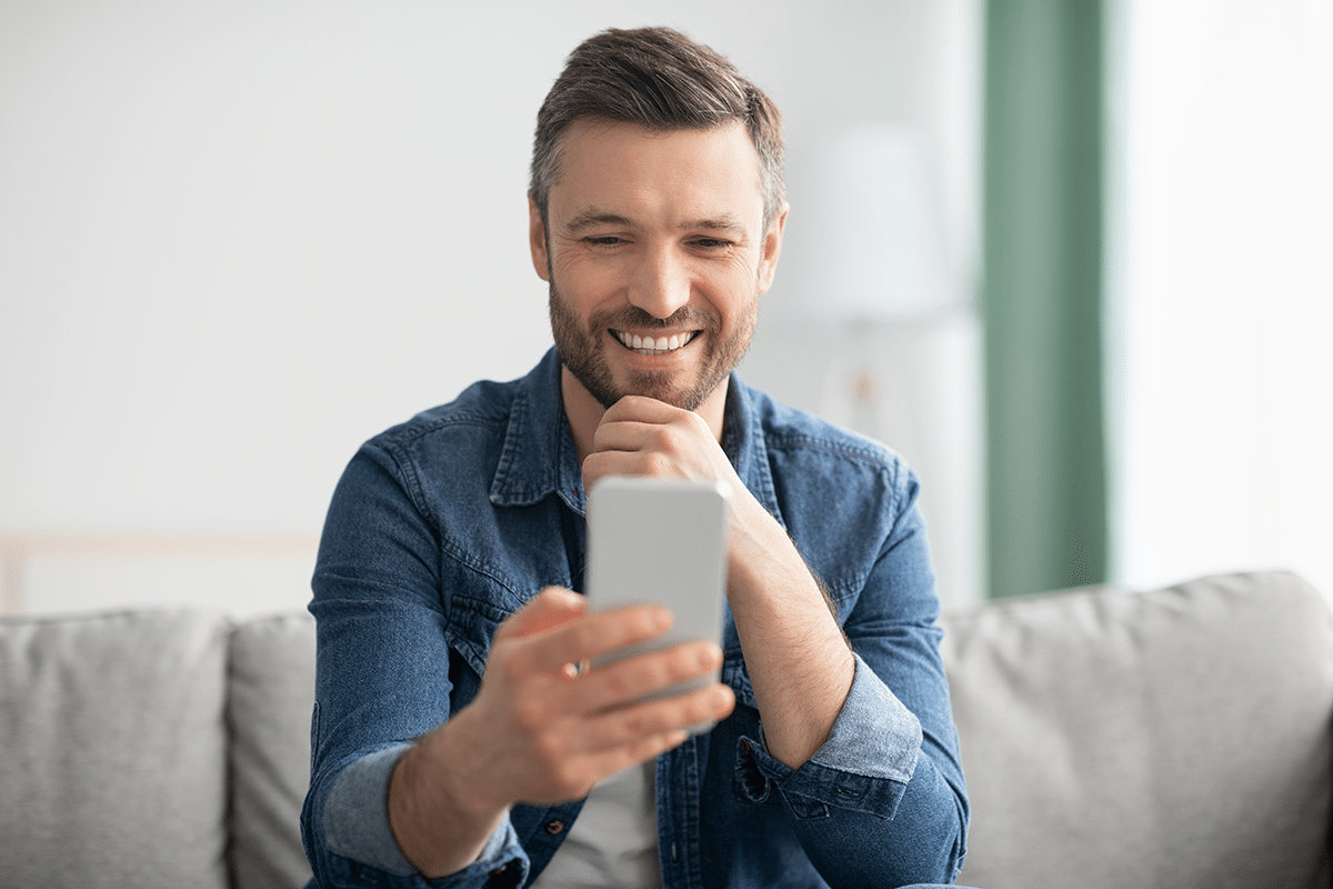 man smiling at phone learning what happens to his benefits if he leaves federal service